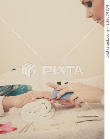 Woman getting manicure done file nails 138574874