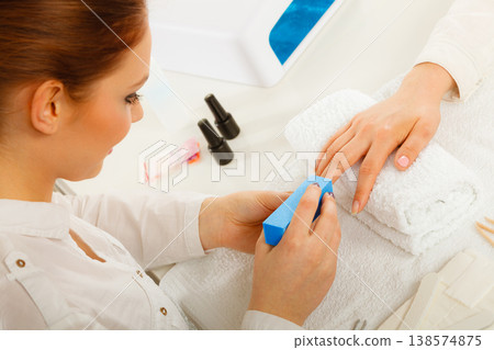 Woman getting manicure done file nails Woman getting manicure done file nails 138574875