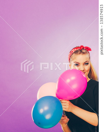 Lovely smiling girl holds colorful balloons. Lovely smiling girl holds colorful balloons. 138574915