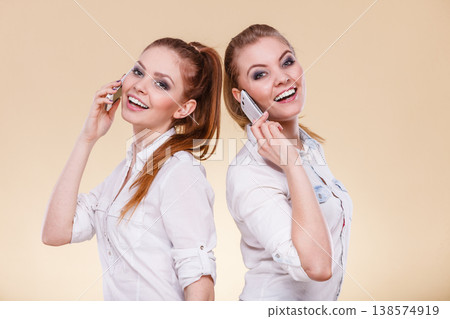 Girls using mobile phone talking Girls using mobile phone talking 138574919