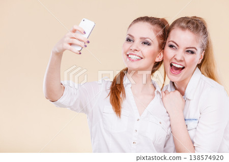 friends student girls taking self photo with smart phone friends student girls taking self photo with smart phone 138574920