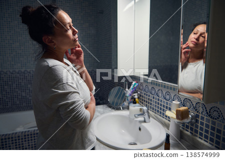 Middle Aged Woman in Pyjamas Caring for Her Face During Morning Beauty Routine 138574999