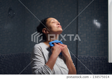 Middle-Aged Woman in Pajamas Doing Morning Facial Care During Daily Hygiene Routine Middle-Aged Woman in Pajamas Doing Morning Facial Care During Daily Hygiene Routine 138575014