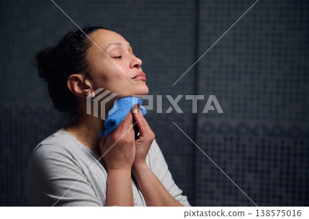 Middle-Aged Woman in Pyjamas Performing Morning Skincare and Hygiene Routine at Home Mirror Middle-Aged Woman in Pyjamas Performing Morning Skincare and Hygiene Routine at Home Mirror 138575016