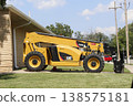 A Cat Telehandler parked in a driveway with blue sky 138575181