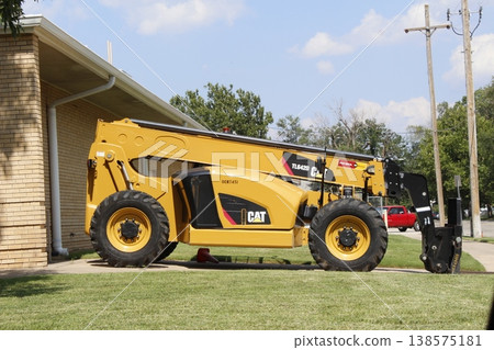 A Cat Telehandler parked in a driveway with blue sky A Cat Telehandler parked in a driveway with blue sky 138575181