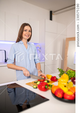 Young vegetarian woman in the kitchen feeling enjoyed while preparing food 138575190