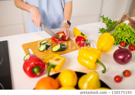 Close up of a person cutting vegetables on a cutting board Close up of a person cutting vegetables on a cutting board 138575193