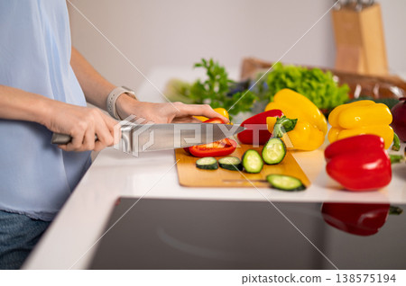 Close up of a person cutting vegetables on a cutting board Close up of a person cutting vegetables on a cutting board 138575194