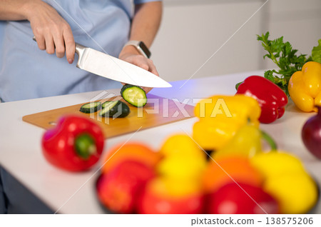 Close up picture of female hands cutting veggies Close up picture of female hands cutting veggies 138575206