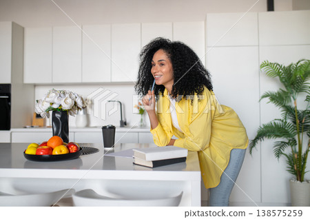 Beautiful young woman sitting at the table and looking inspired and excited Beautiful young woman sitting at the table and looking inspired and excited 138575259