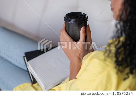 Young woman having coffee at home and feeling peaceful and comfortable Young woman having coffee at home and feeling peaceful and comfortable 138575284