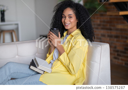 Young woman having coffee at home and feeling peaceful and comfortable Young woman having coffee at home and feeling peaceful and comfortable 138575287