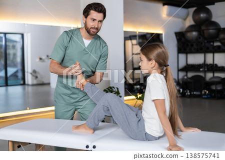 Specialist massaging child foot for recovery in clinic Specialist massaging child foot for recovery in clinic 138575741