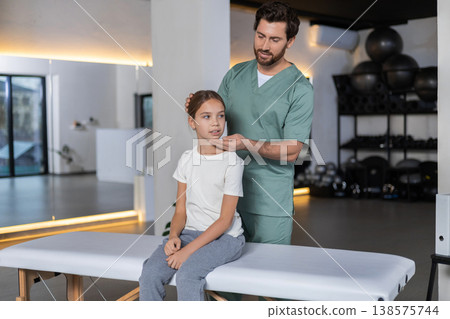 Doctor checking neck mobility of child patient Doctor checking neck mobility of child patient 138575744