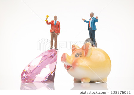 Miniature people with trophy and gem stand on piggy bank in creative display scene about finance  138576051