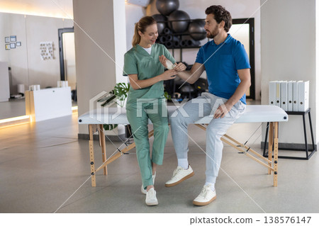Doctor assisting male patient with hand rehabilitation 138576147