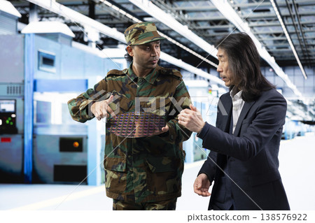 Military man discussing strategic silicon wafer supply chain with corporate executive. Army officer and PCB factory manager reviewing strategic microchip technology production 138576922