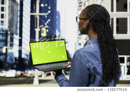 Green screen mockup laptop used by digital nomad working, composing emails. African american woman using chroma key isolated screen notebook to write to business partners, doing freelancing outside Green screen mockup laptop used by digital nomad working, composing emails. African american woman using chroma key isolated screen notebook to write to business partners, doing freelancing outside 138577010