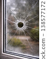 Bullet hole in window glass with cracks close up 138577172