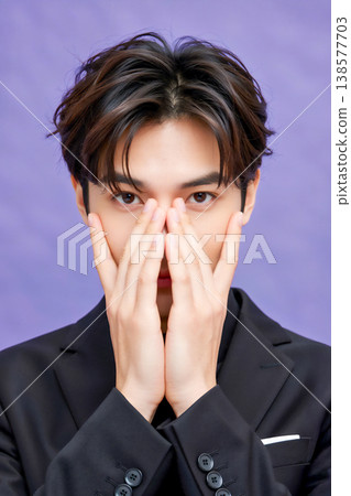 一位面無表情的商人，用手遮住了臉。 138577703