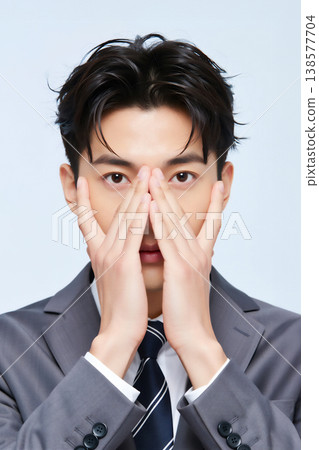 一位面無表情的商人，用手遮住了臉。 138577704