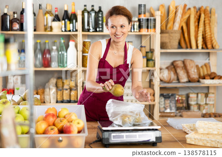 Supermarket produce department worker weighs pears on scales for sale 138578115