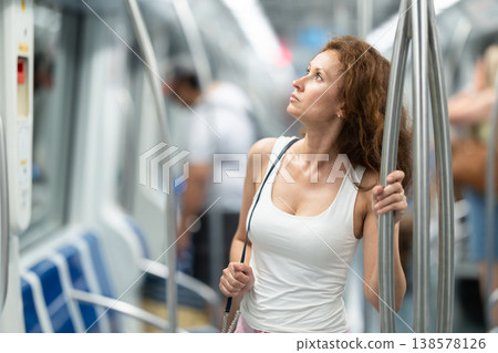 Portrait of woman passenger standing inside train at metro wagon Portrait of woman passenger standing inside train at metro wagon 138578126