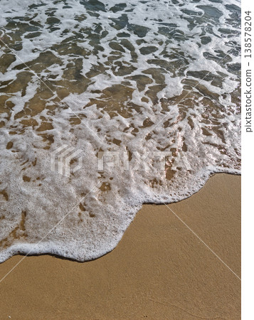 It is a sandy beach with waves rolling in. It is a sandy beach with waves rolling in. 138578204