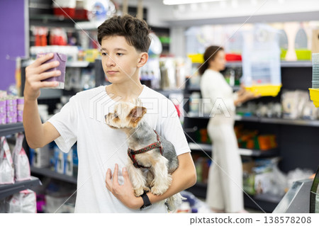 Preteen boy selecting dry dog food for Yorkie in pet store Preteen boy selecting dry dog food for Yorkie in pet store 138578208