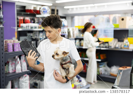Teenager choosing dry dog food for Yorkshire terrier in pet store Teenager choosing dry dog food for Yorkshire terrier in pet store 138578317