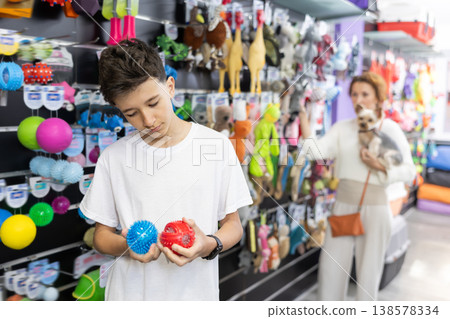 Teenage boy chooses balls for animal in pet store Teenage boy chooses balls for animal in pet store 138578334