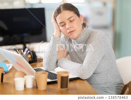 Tired young woman working on laptop Tired young woman working on laptop 138578463