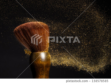 Big Soft Makeup brush with powder explosion. Cosmetic brush splash powder dust with gold glitter sparkling for make up. Black background isolated on photo element Big Soft Makeup brush with powder explosion. Cosmetic brush splash powder dust with gold glitter sparkling for make up. Black background isolated on photo element 138578585