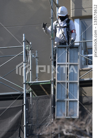 Dismantling site of temporary scaffolding during large-scale apartment building renovation. Dismantling site of temporary scaffolding during large-scale apartment building renovation. 138578612