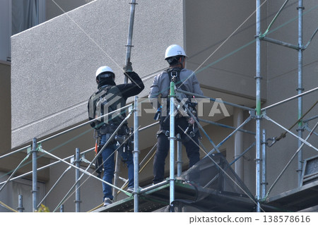 Dismantling site of temporary scaffolding during large-scale apartment building renovation. Dismantling site of temporary scaffolding during large-scale apartment building renovation. 138578616