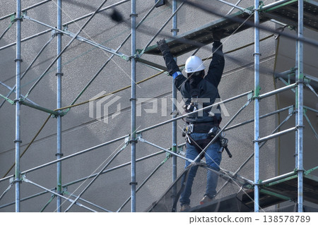 Dismantling site of temporary scaffolding during large-scale apartment building renovation. Dismantling site of temporary scaffolding during large-scale apartment building renovation. 138578789