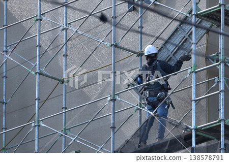 Dismantling site of temporary scaffolding during large-scale apartment building renovation. Dismantling site of temporary scaffolding during large-scale apartment building renovation. 138578791