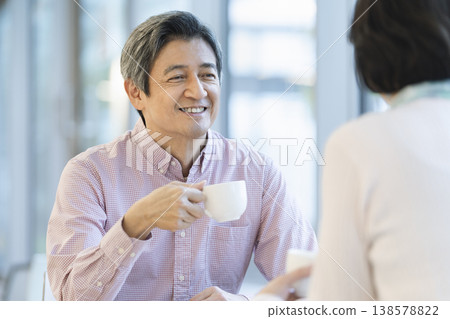 一對六十多歲的夫婦在咖啡館放鬆休息。 一對六十多歲的夫婦在咖啡館放鬆休息。 138578822