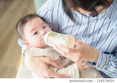 Father giving milk to baby Father giving milk to baby 138579034