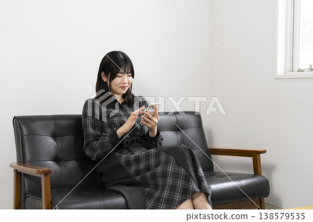 A woman using a mobile phone A woman using a mobile phone 138579535