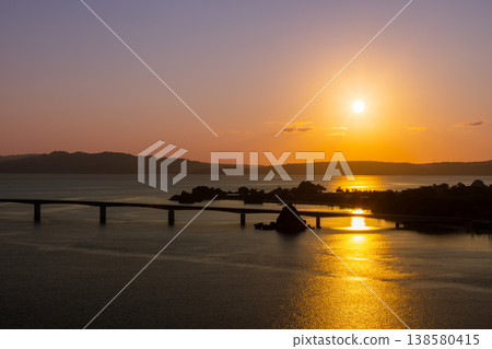 A view of the sunrise and dawn over Kouri Bridge from the Unten Mori Park Observation Deck in Unten, Nakijin Village, Kunigami District, Okinawa Prefecture. A view of the sunrise and dawn over Kouri Bridge from the Unten Mori Park Observation Deck in Unten, Nakijin Village, Kunigami District, Okinawa Prefecture. 138580415