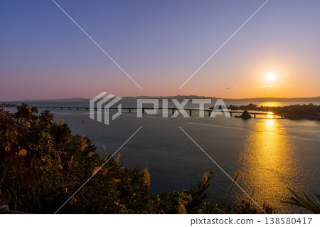A view of the sunrise and dawn over Kouri Bridge from the Unten Mori Park Observation Deck in Unten, Nakijin Village, Kunigami District, Okinawa Prefecture. 138580417