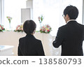 喪親家屬的背影和在葬禮現場接受指示的工作人員。 138580793