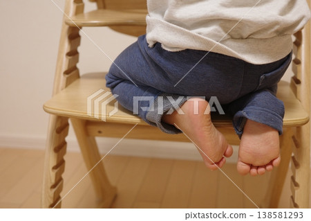 特寫鏡頭拍攝一名1歲嬰兒跪在嬰兒椅上的小腳。 特寫鏡頭拍攝一名1歲嬰兒跪在嬰兒椅上的小腳。 138581293