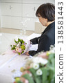 殯葬工作人員輕輕地擺放著葬禮鮮花。 138581443