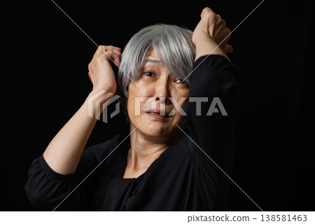 一張老婦人驚恐萬分、眼含淚水的照片。 138581463