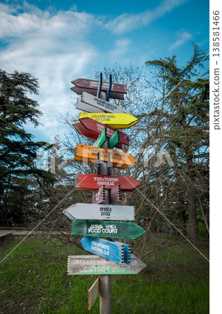 Rustic multi-colored wooden arrows pointing to various park locations like the funicular and zoo Rustic multi-colored wooden arrows pointing to various park locations like the funicular and zoo 138581466