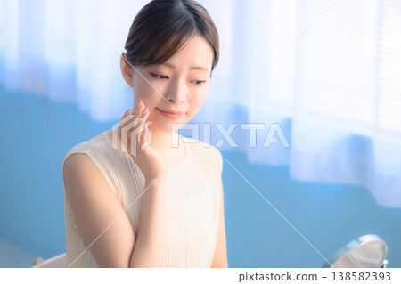 Japanese woman doing skincare while looking in the mirror: Happy Pop Japanese woman doing skincare while looking in the mirror: Happy Pop 138582393