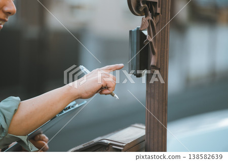 一名身穿工作服、手拿文件夾的男子按了門鈴。 138582639